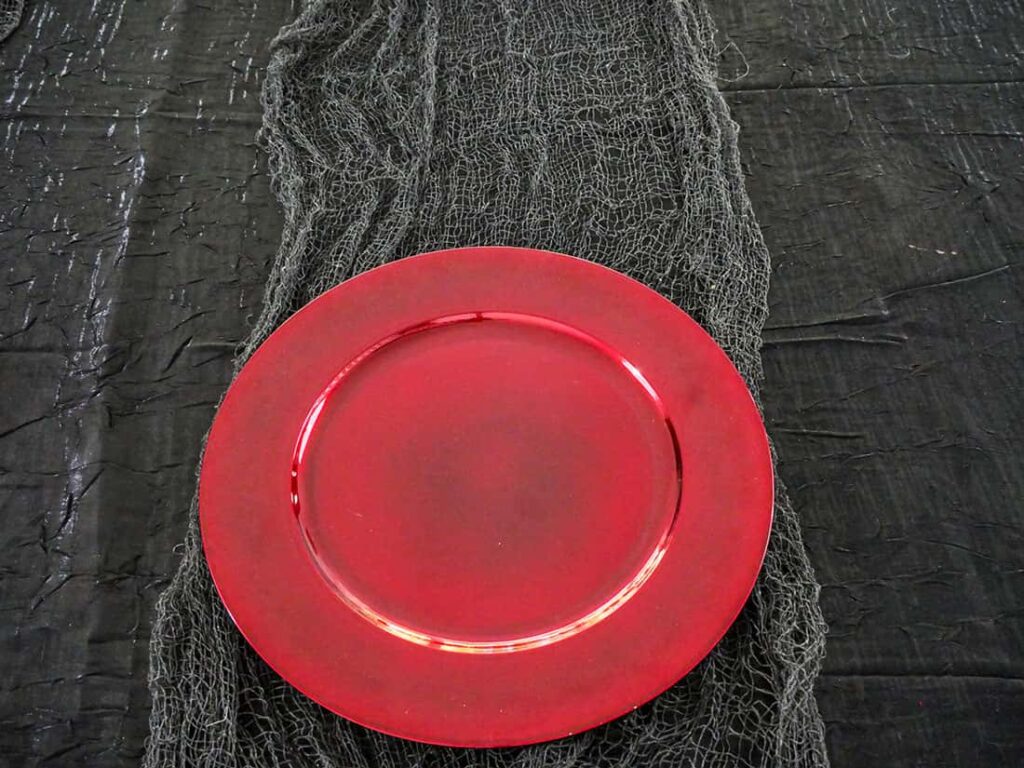 Red charger on spooky Halloween tablescape.