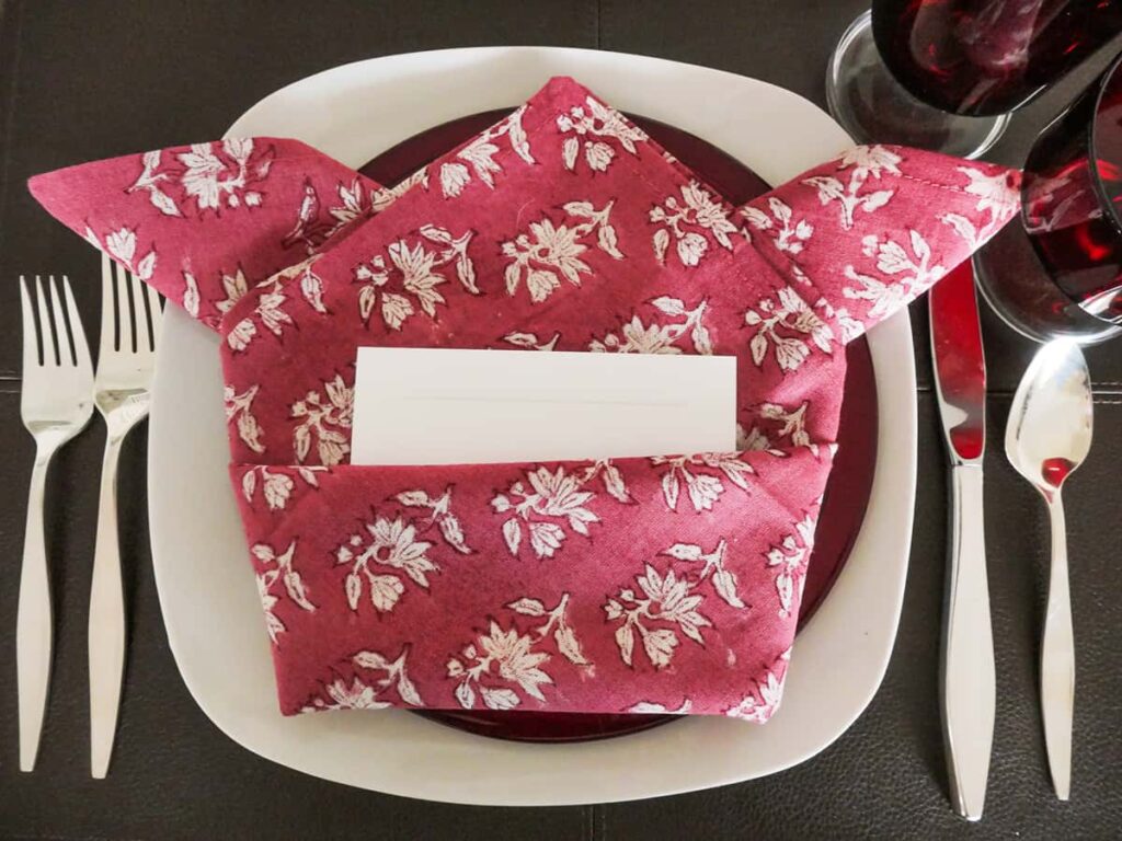 Close up of folded napkin created for romantic table setting for two.