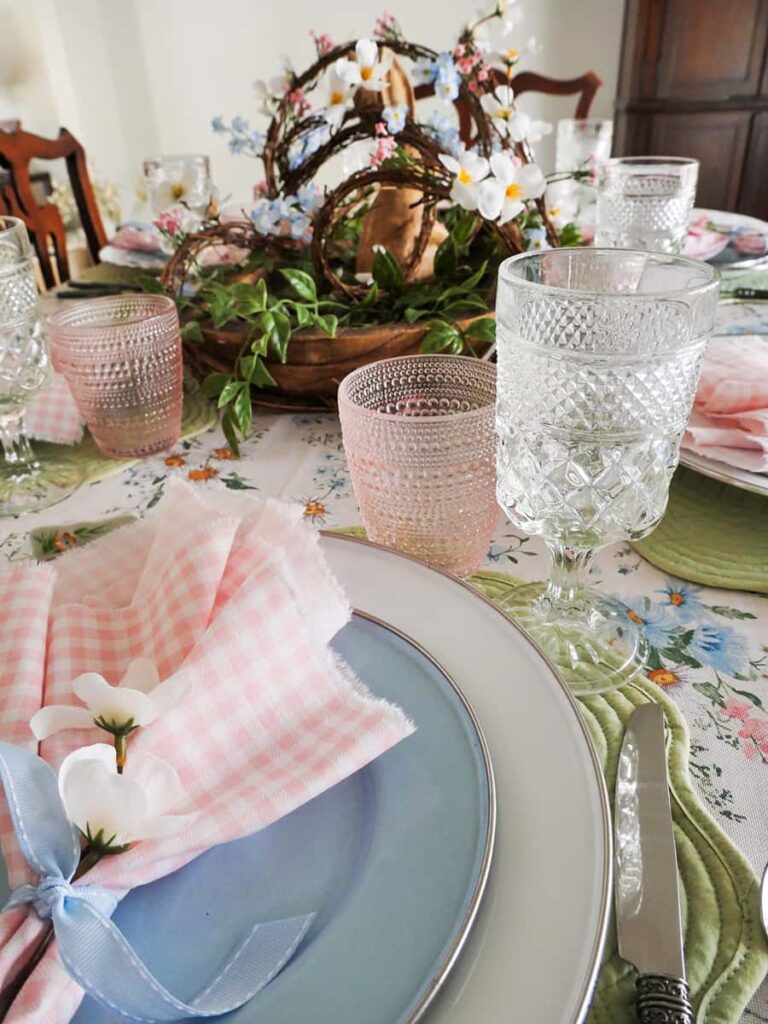 Easter tablescape on a budget with white and blue plates and the centerpiece in the background.
