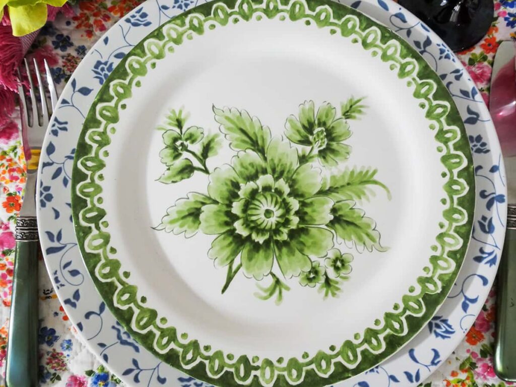 Green and white salad plate on top of dinner plate.