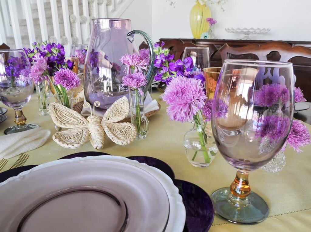 Spring tablescape with lavender glasses and cream butterflies.