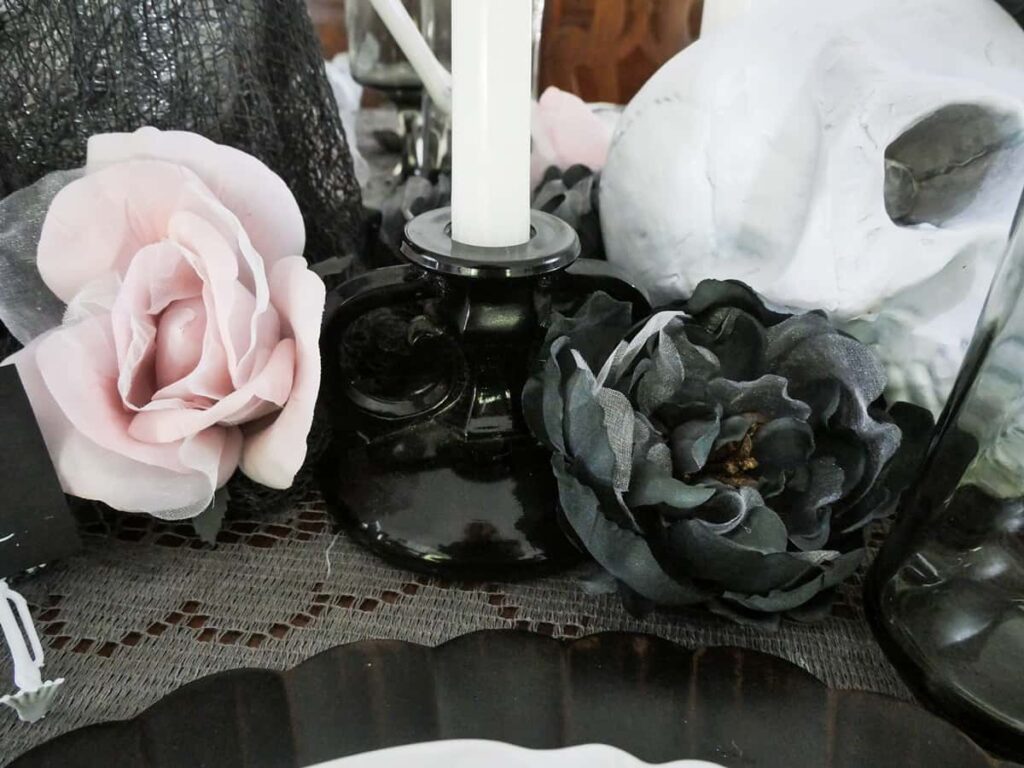 Dusty pink and soft black flowers on the Halloween table setting.