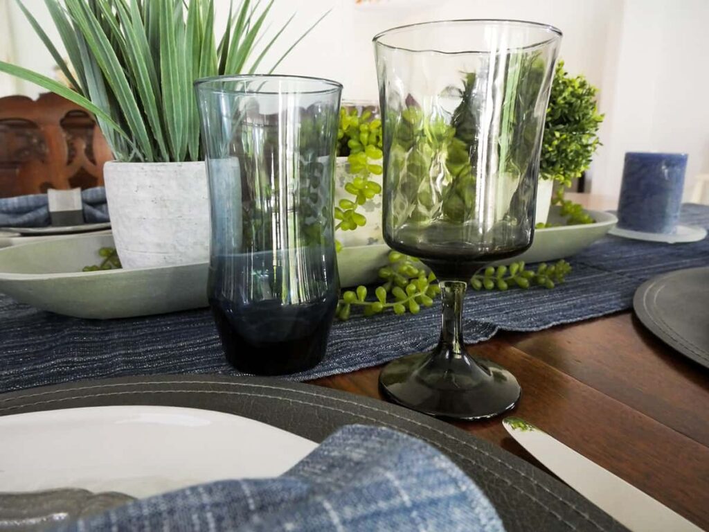 Blue water glass next to grey wine glass.