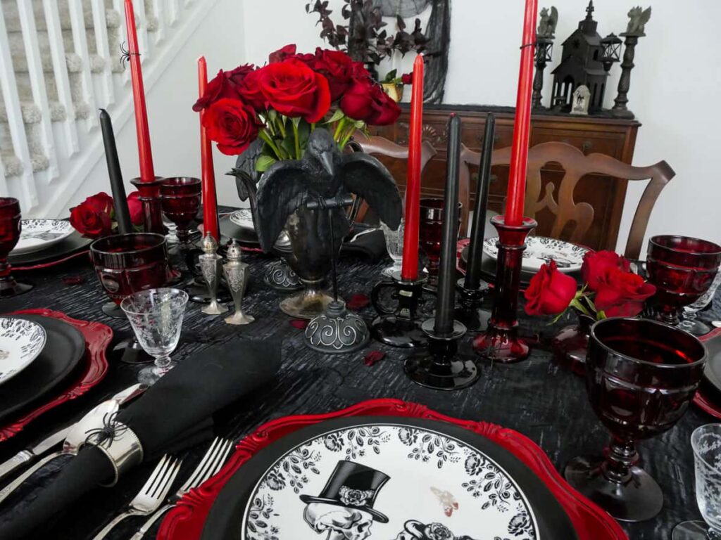 Completed Halloween centerpiece with a black crown and red roses in the back.