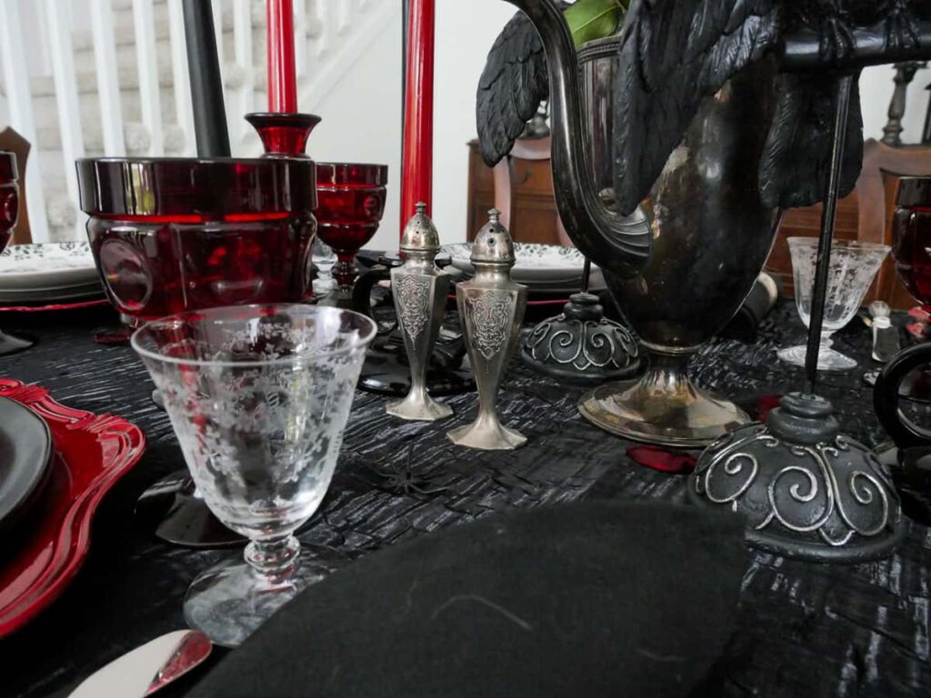 Silver salt and pepper shakers on a black tablecloth.