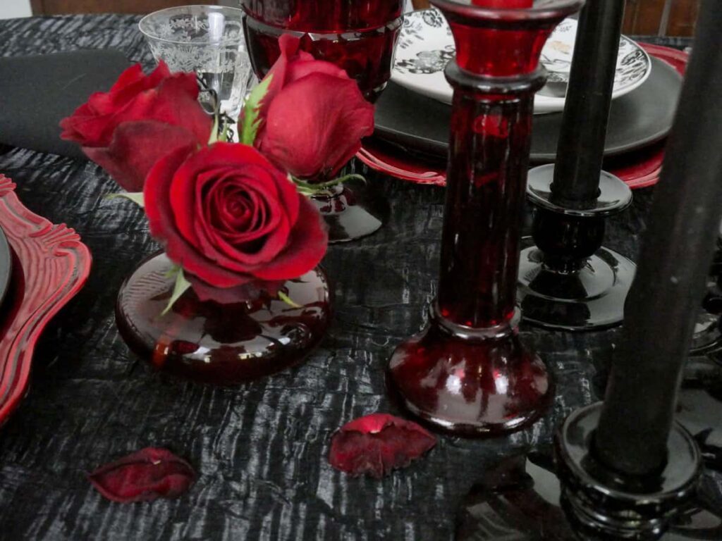 Close up of red roses in a red bud vase.