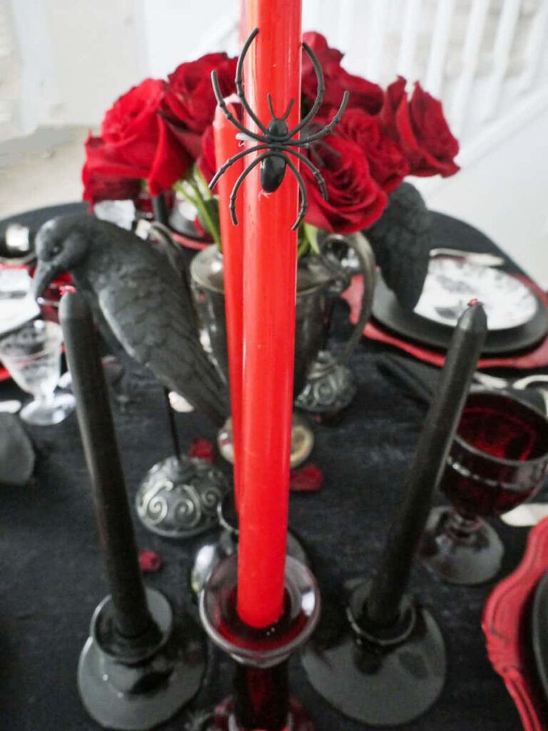 Fake spider on a red taper candle.